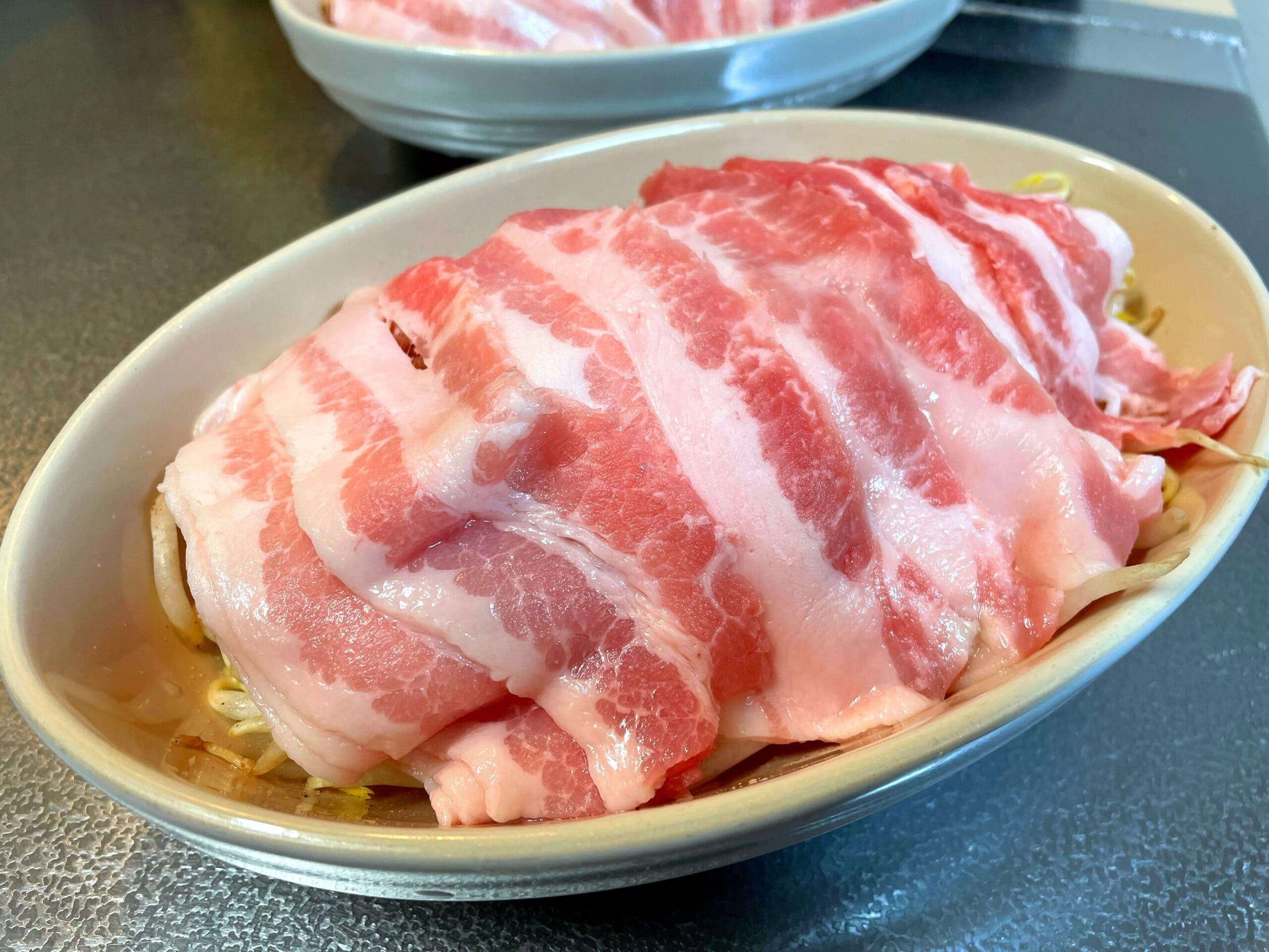 もやしの上に豚薄切り肉を重ねた電子レンジ加熱前の状態