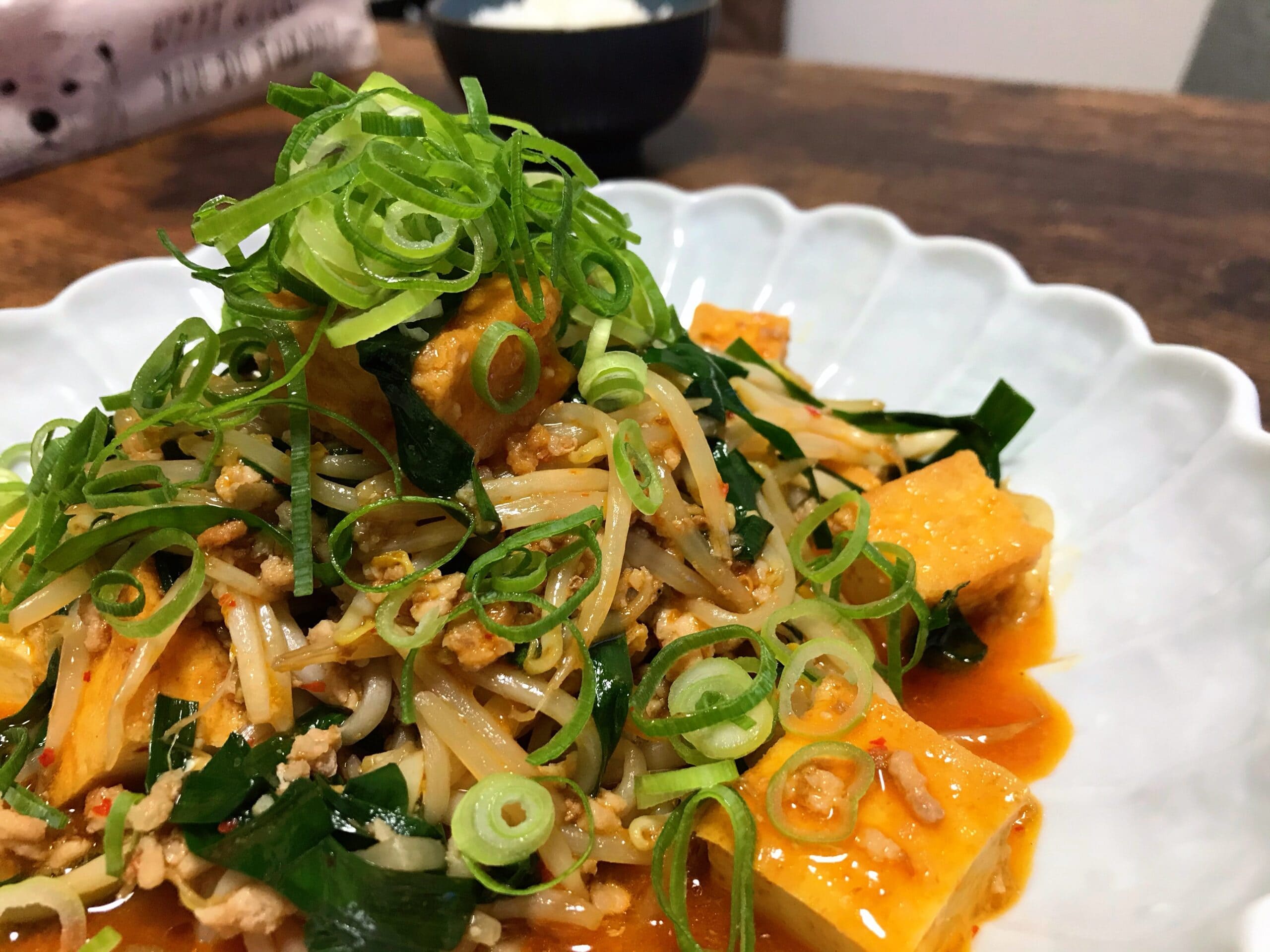 ピリ辛ダレで炒めたもやしと豆腐に刻みネギをたっぷりのせた完成写真