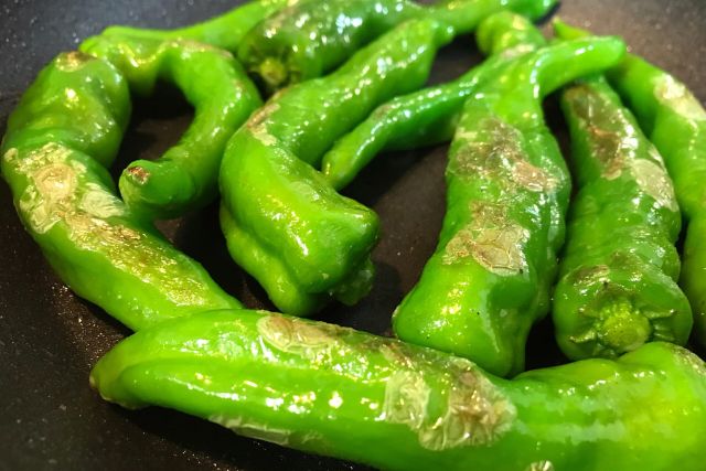 フライパンで甘長唐辛子を炒めている途中の様子。表面にツヤが出た状態がベスト
