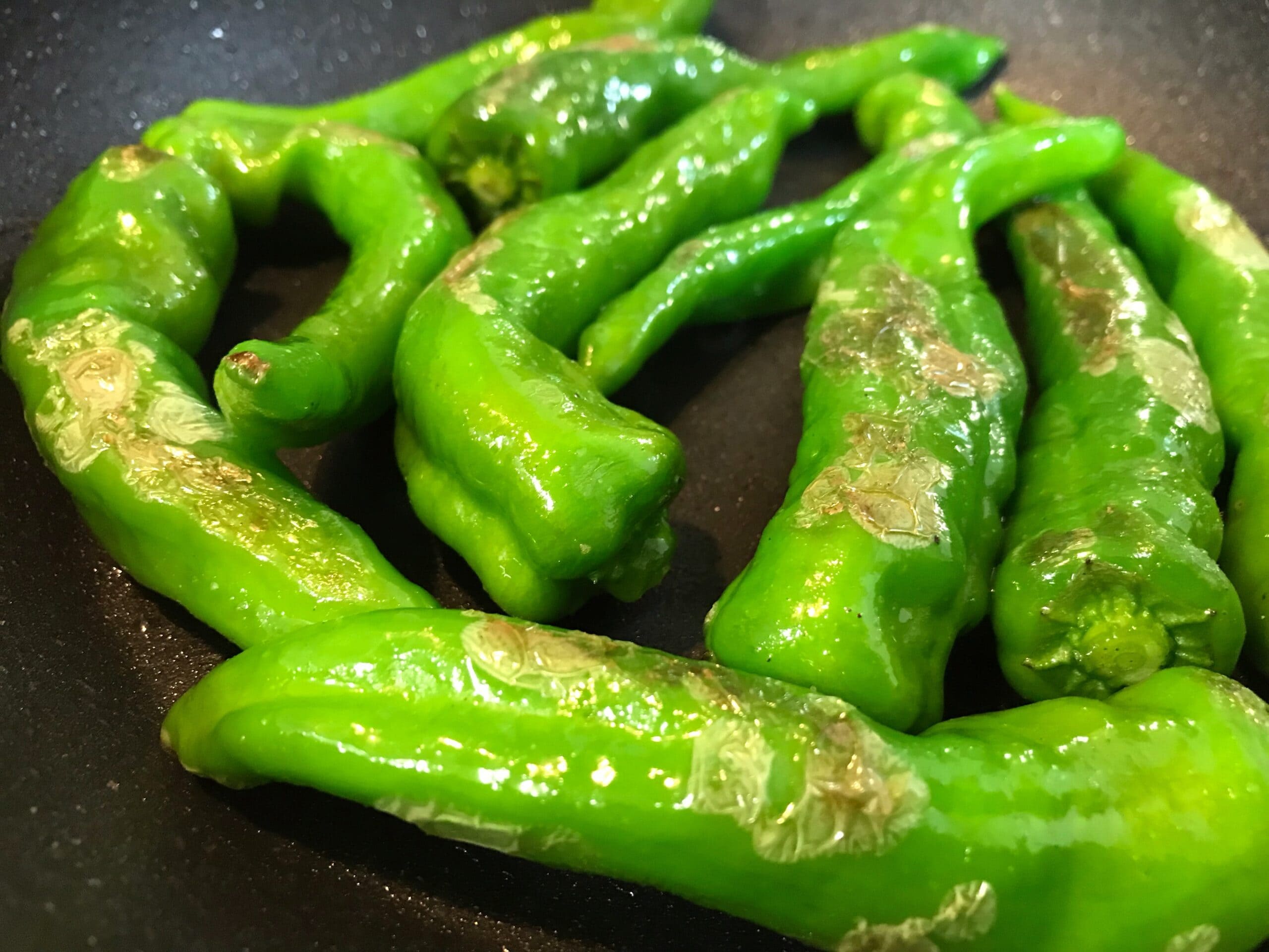 フライパンで甘長唐辛子を焼いている調理途中の様子。おつまみ炒めの工程写真