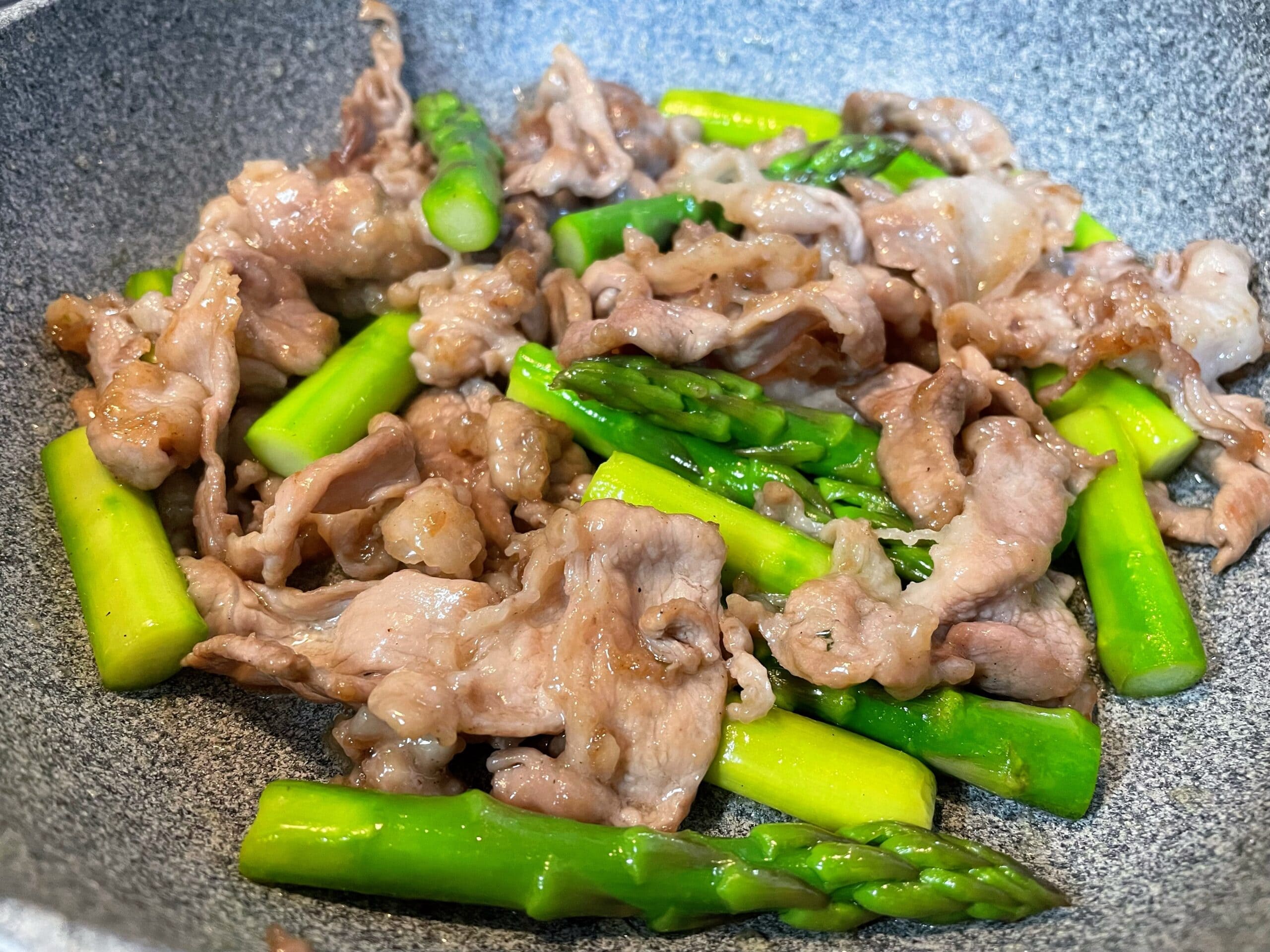 フライパンで豚肉とアスパラを炒めている塩レモン炒めの調理途中