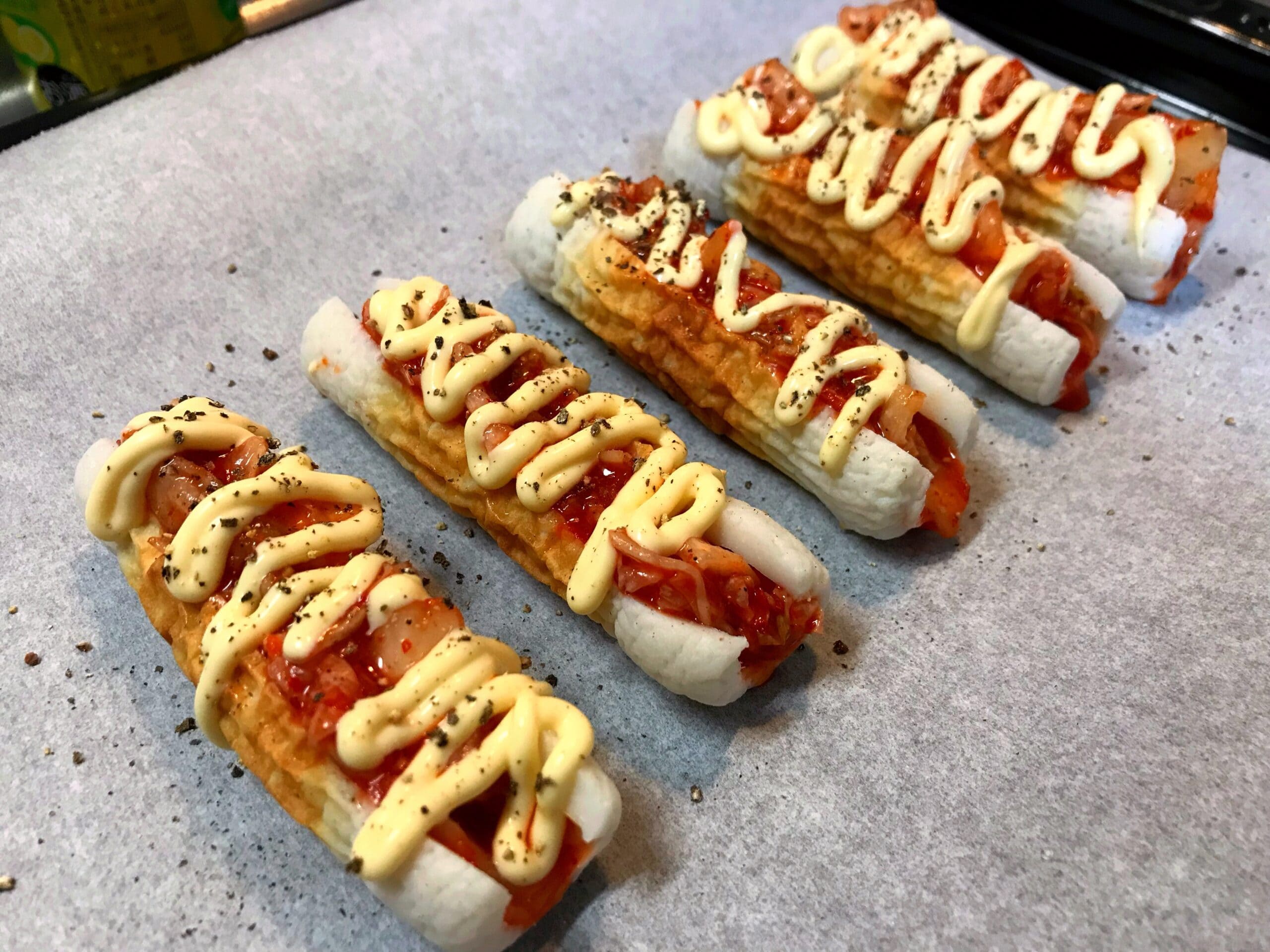 ちくわに切り込みを入れてキムチを詰めマヨネーズをのせた調理途中の写真