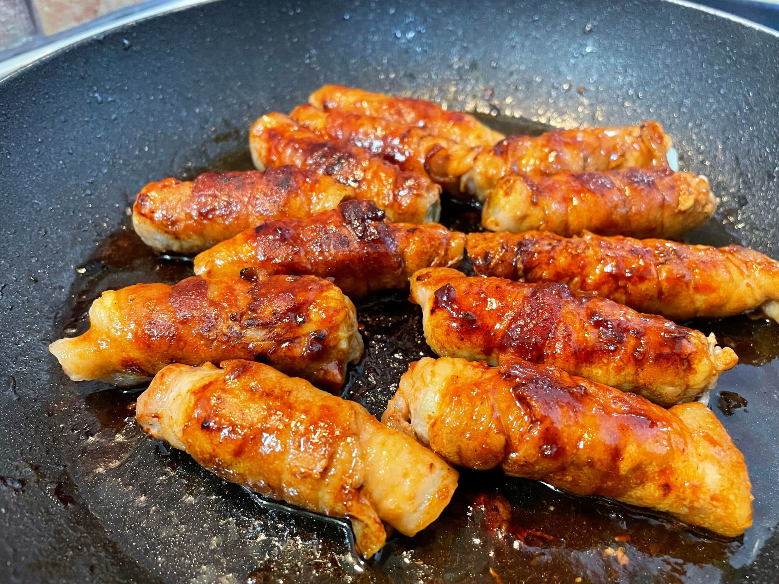 フライパンで焼いている途中の長ネギの豚肉巻き調理工程