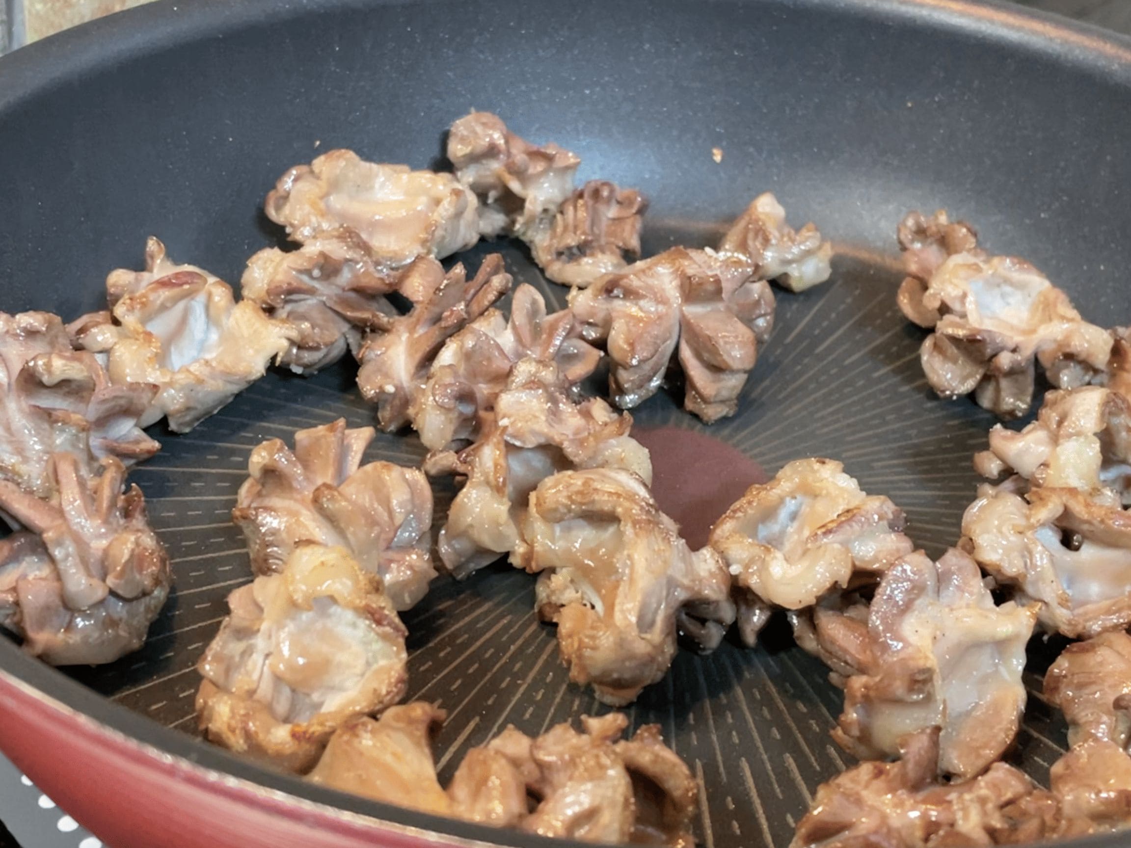 フライパンで砂肝を炒めてコリコリ食感を引き出している工程