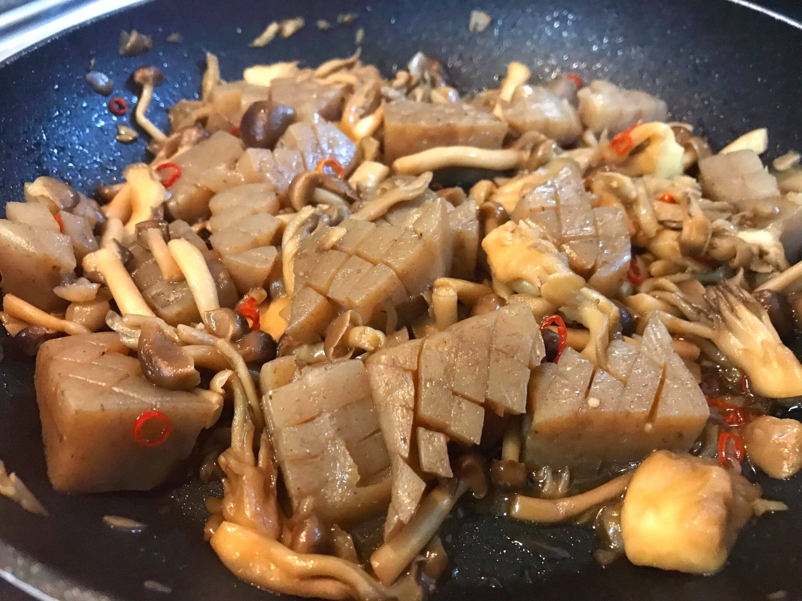 たっぷりきのことこんにゃくをガリバタ醤油でフライパン調理している様子
