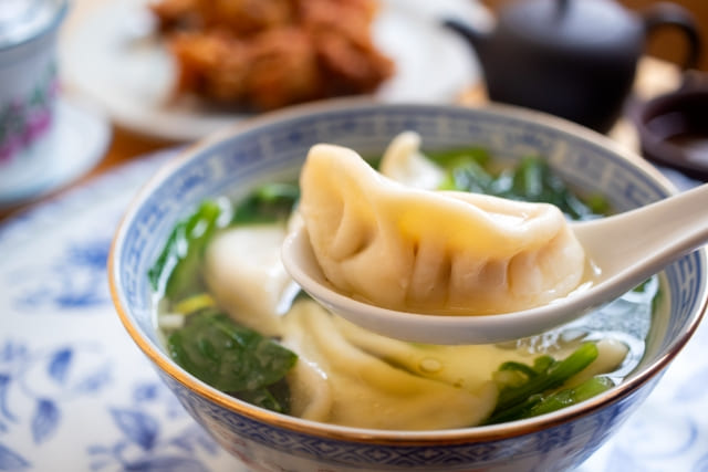 チンゲン菜入り餃子味噌汁の餃子をスプーンで持ち上げた写真