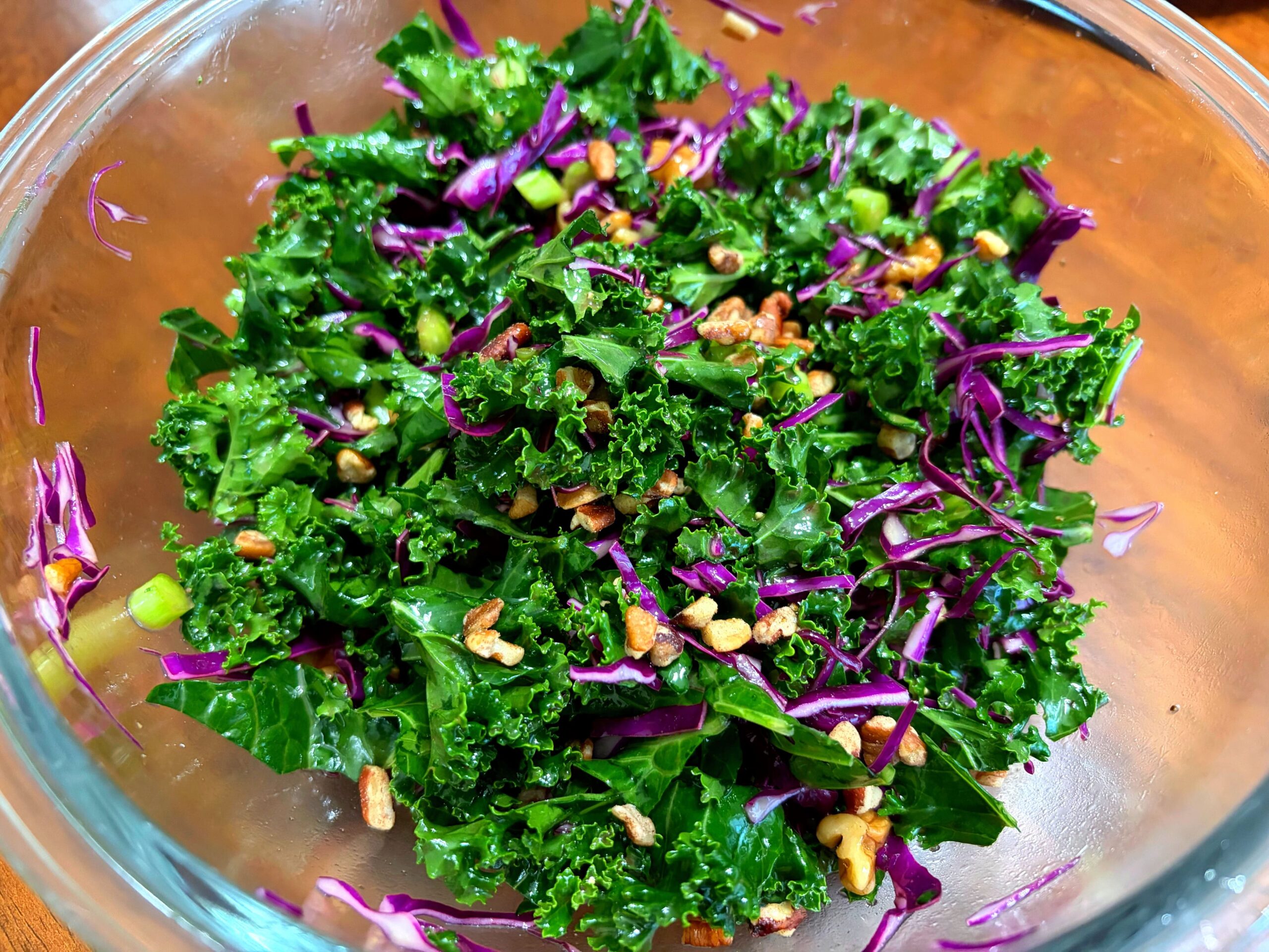 ケールと紫キャベツ ナッツをドレッシングで和えている様子