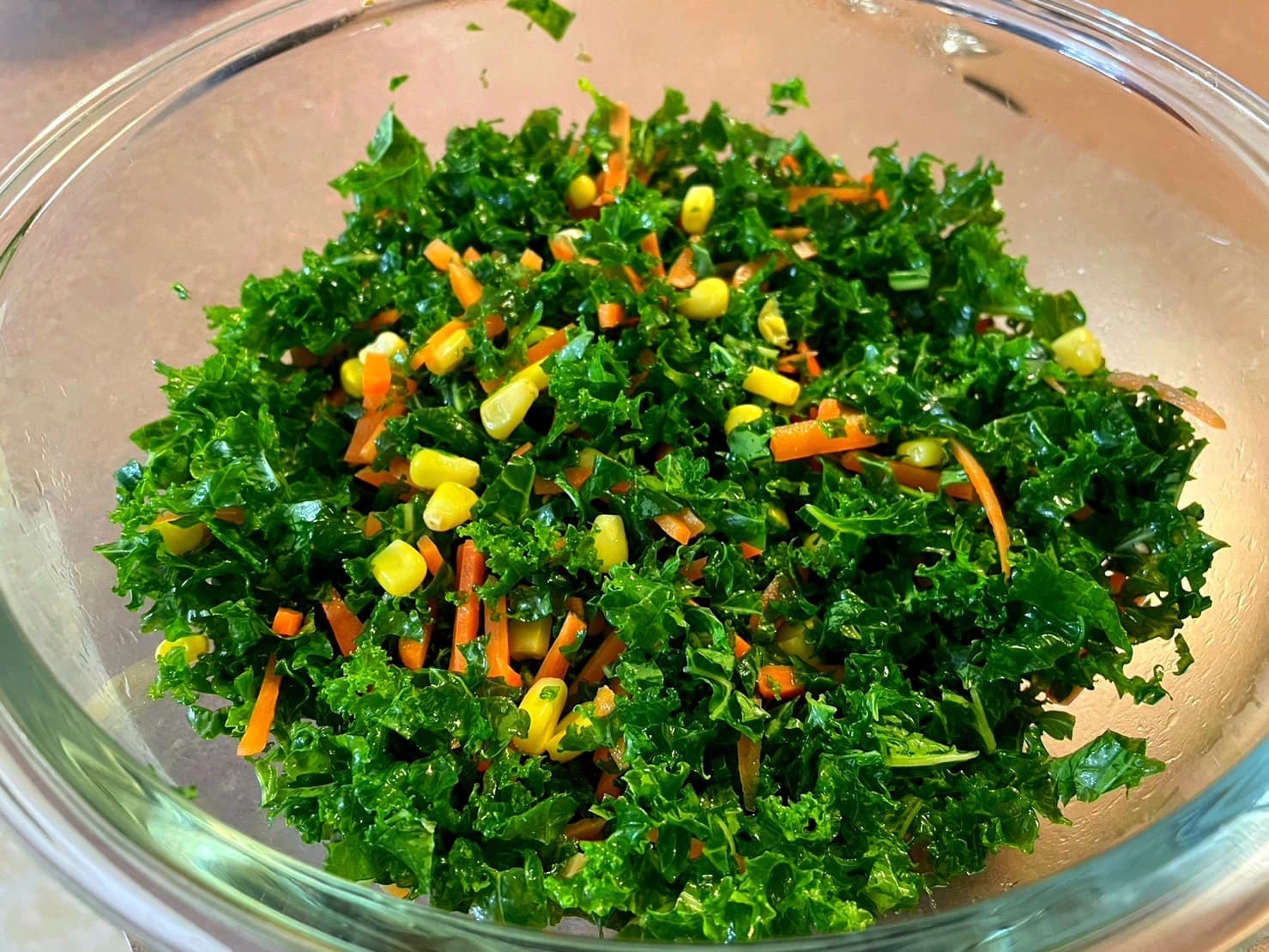 刻んだケールと野菜を和風ドレッシングで混ぜ合わせている工程写真