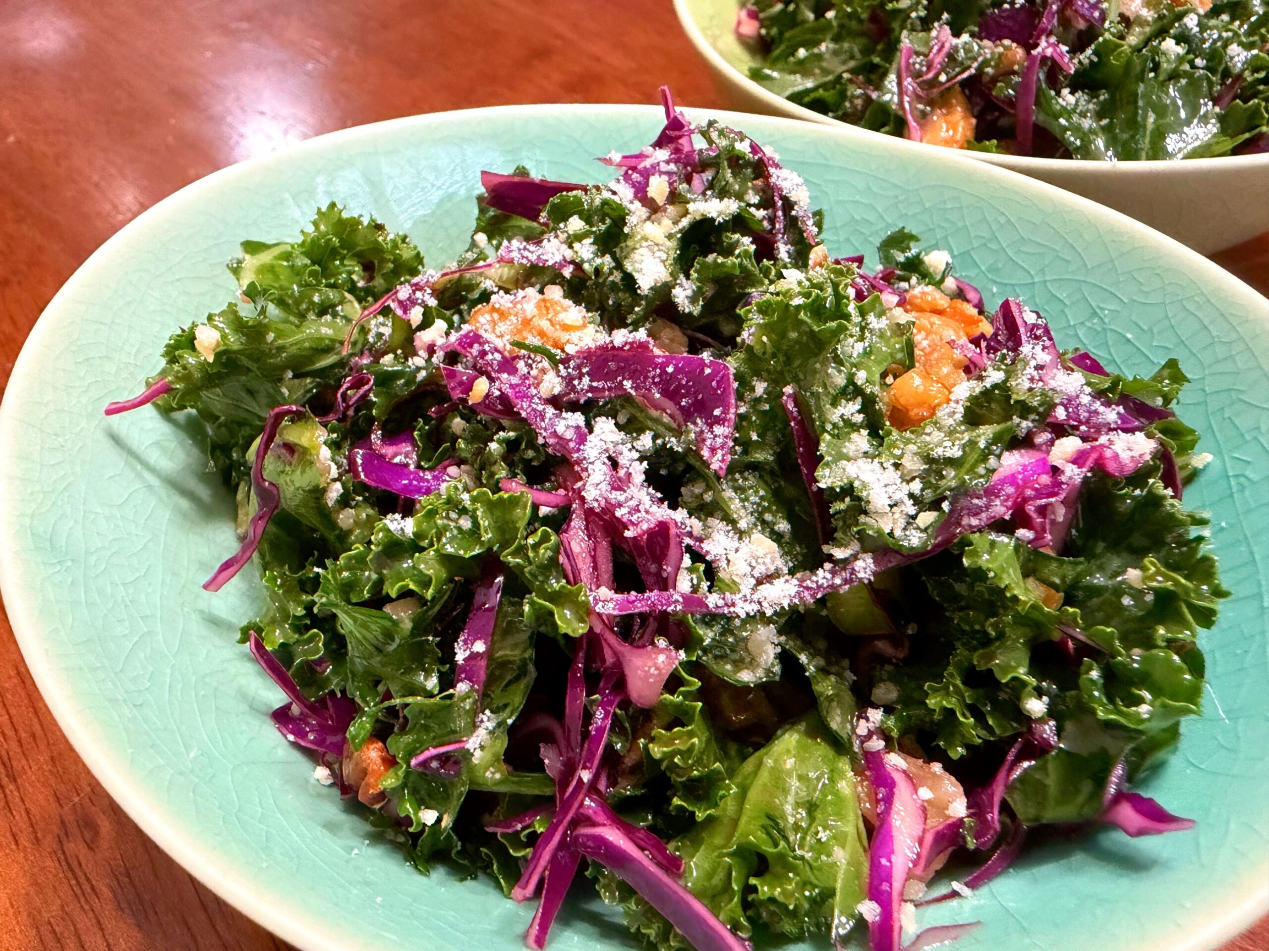 ナッツと紫キャベツを使ったケールサラダにハニーマスタードドレッシングをかけたおしゃれなサラダ