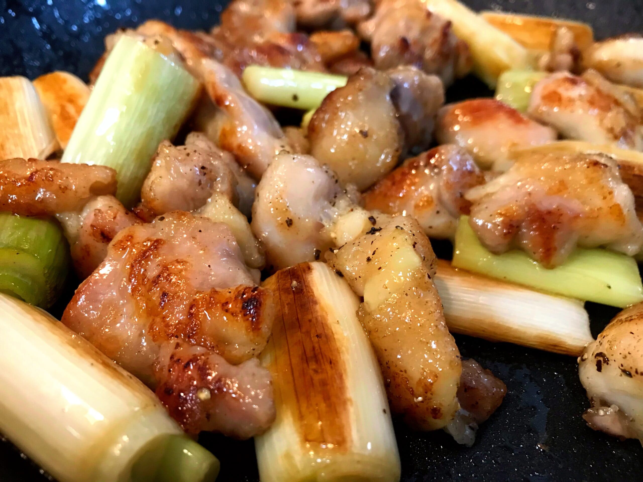 フライパンで鶏もも肉と長ねぎを焼いている塩焼き鳥の調理途中の様子