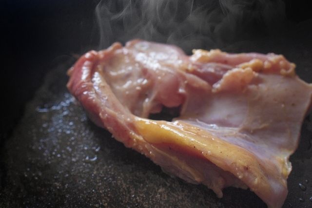 フライパンで鶏もも肉を皮目から焼いている塩焼き鳥の調理工程