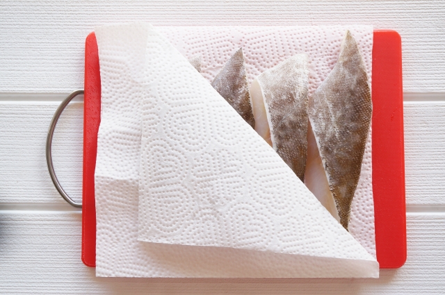 キッチンペーパーでタラの水分を拭き取る下処理の様子