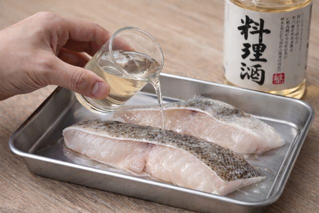 タラの切り身に料理酒をかけて臭み取りをする下処理