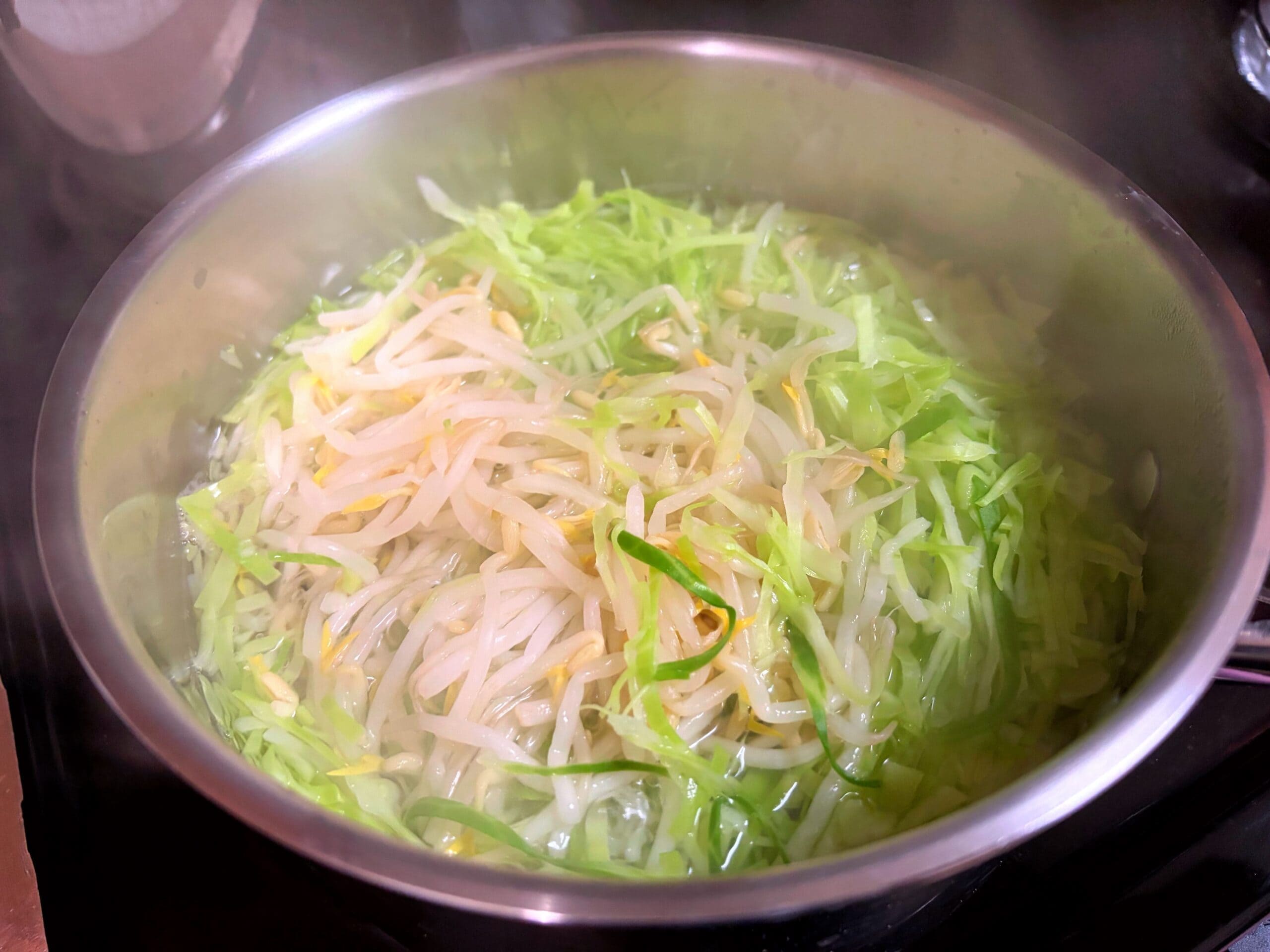 豚ニンニク醤油の野菜マシマシ二郎パスタ用に、鍋でもやしとキャベツをサッと短時間で下茹でしている調理途中の写真