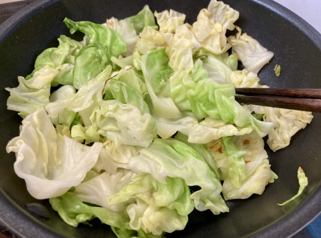 キャベツをフライパンでさっと炒めている写真