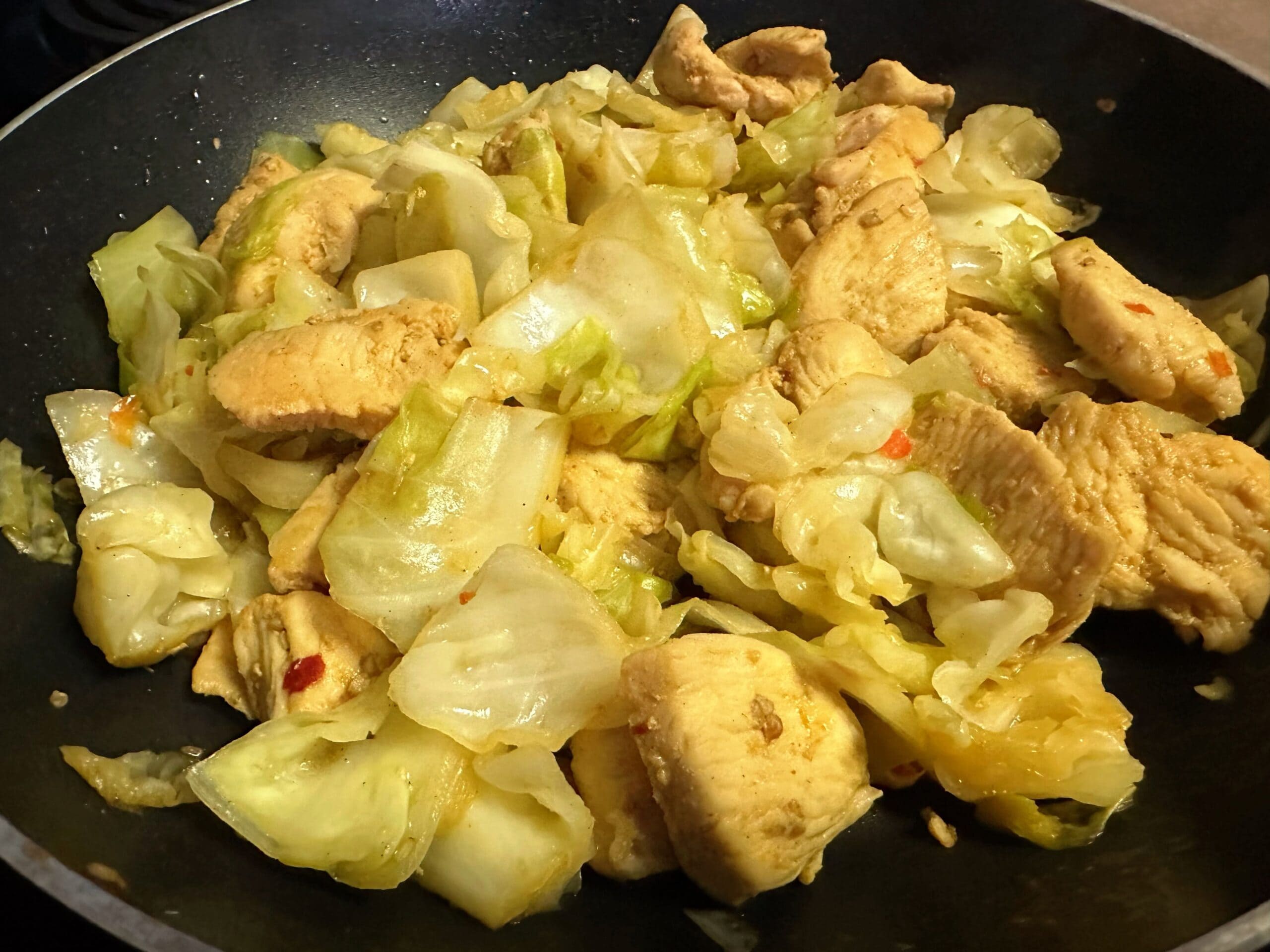 フライパンで焼いた鶏むね肉と炒めたキャベツを戻し入れ、ピリ辛味に炒め合わせている写真