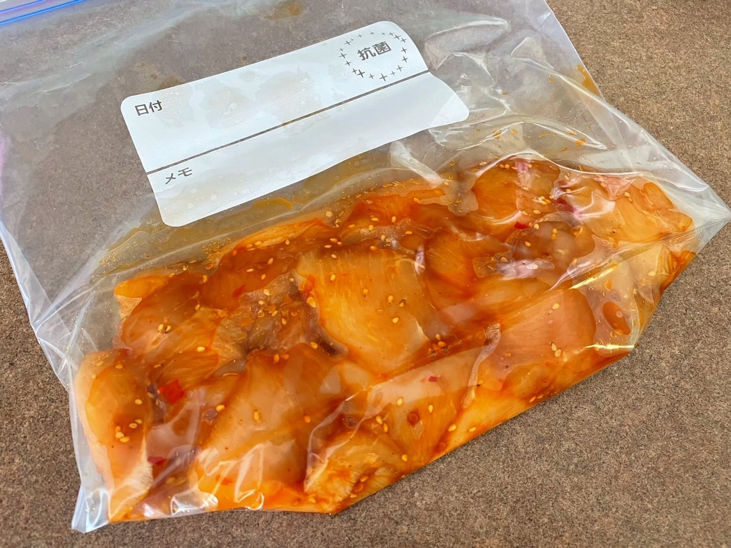 鶏むね肉にピリ辛の下味をつけて保存袋に入れ、下味冷凍できる状態にした写真
