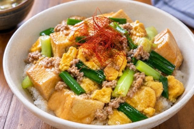 厚揚げ、豚ひき肉、卵そぼろ、ざく切り万能ねぎ、糸唐辛子をのせた厚揚げのネギ玉そぼろあんかけ丼