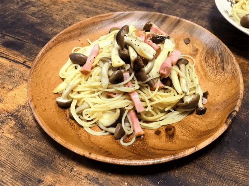 木皿に盛り付けたベーコンとしめじ入りの和風パスタ。醤油の香ばしさが楽しめる簡単パスタレシピ