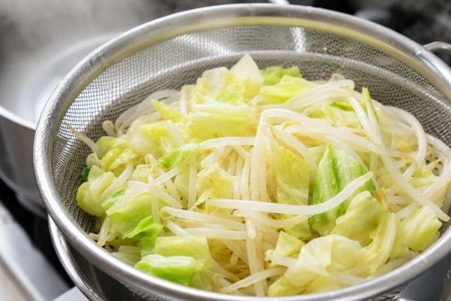 豚ニンニク醤油の野菜マシマシ二郎パスタ用に、もやしとキャベツを鍋でさっと下茹でしている写真