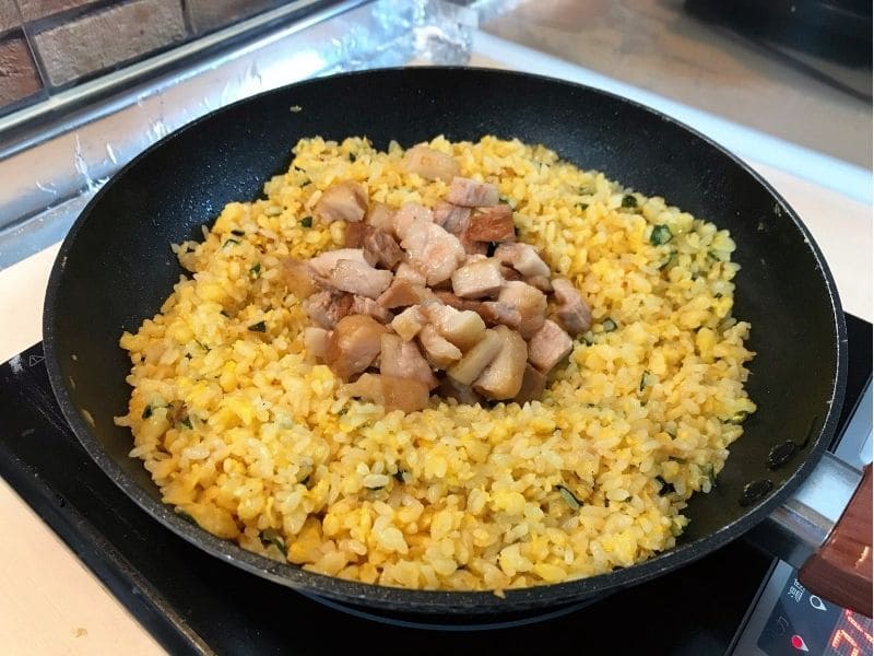 パラパラに炒めたご飯に豚の角煮を加えて、角煮チャーハンを作っている調理工程
