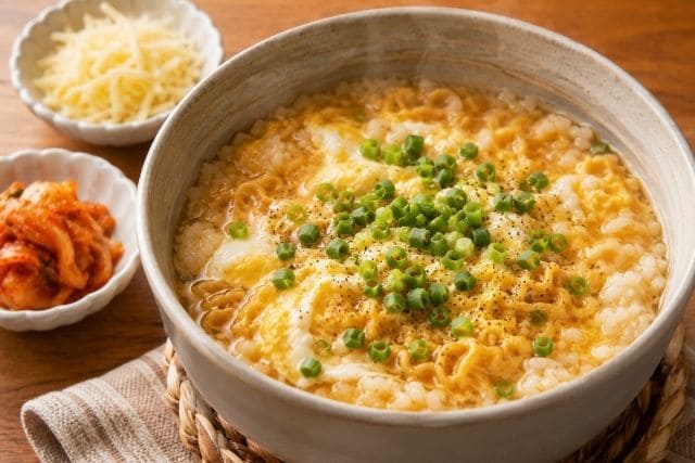 卵と小ねぎをのせたチキンラーメン雑炊に、チーズとキムチを添えた簡単アレンジ写真