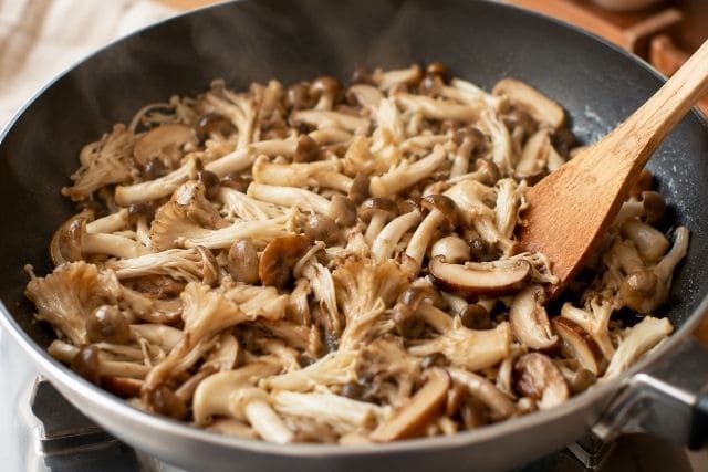 フライパンでしめじや舞茸などのきのこを炒め、香りと旨みを引き出している様子
