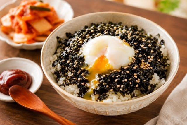 韓国海苔フレークと温泉卵の丼にキムチとコチュジャンを添えた写真