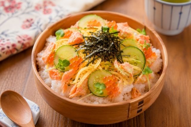 きゅうりの薄切りと鮭フレーク、錦糸卵、刻み海苔をのせた彩りのよいちらし寿司の写真