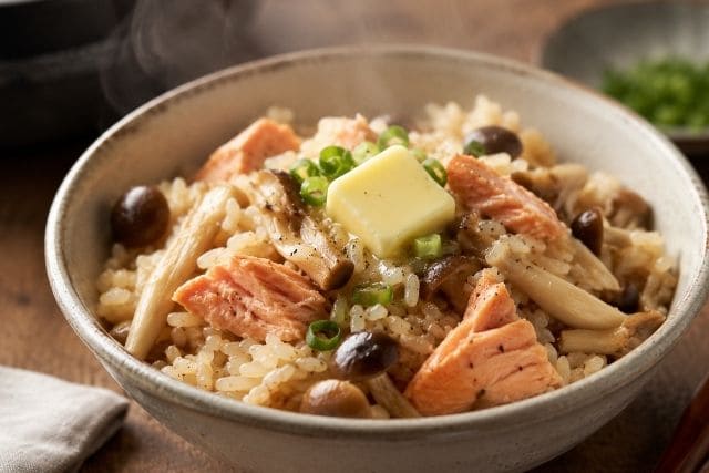 鮭とキノコの炊き込みご飯にバターをのせてコクを出した写真