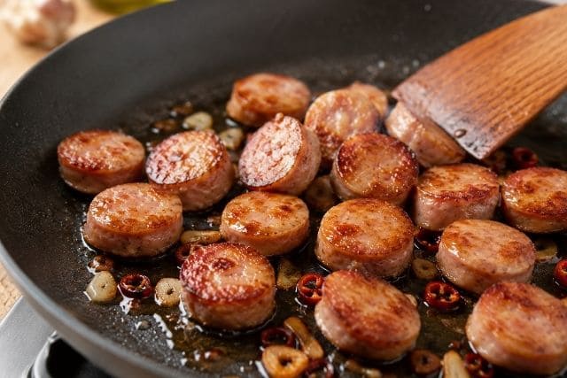 フライパンで輪切りソーセージに焼き目をつけるペペロンチーノの調理工程