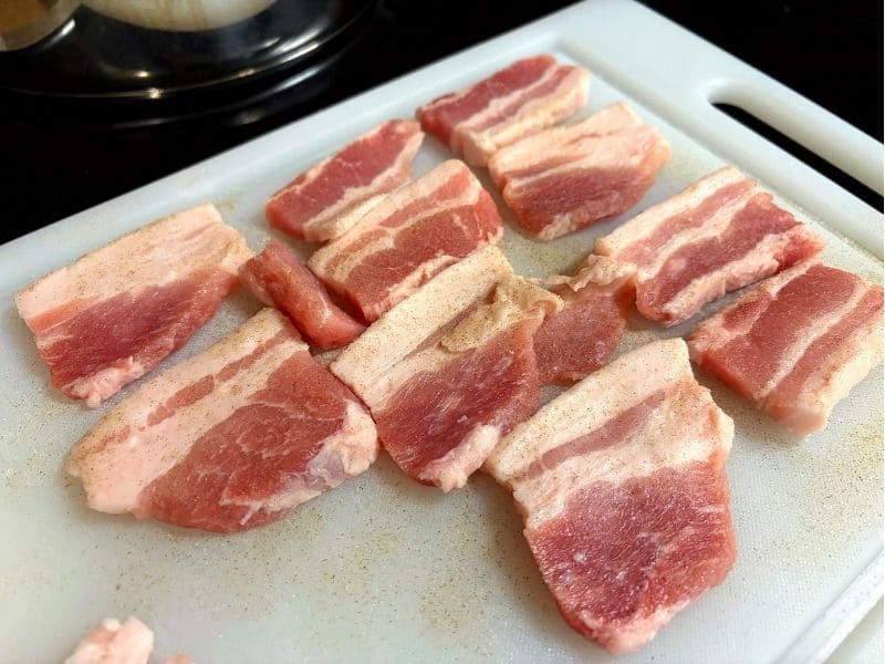 豚ニンニク醤油の野菜マシマシ二郎パスタ用に、豚バラ肉を厚めにスライスして塩コショウで下味をつけている写真