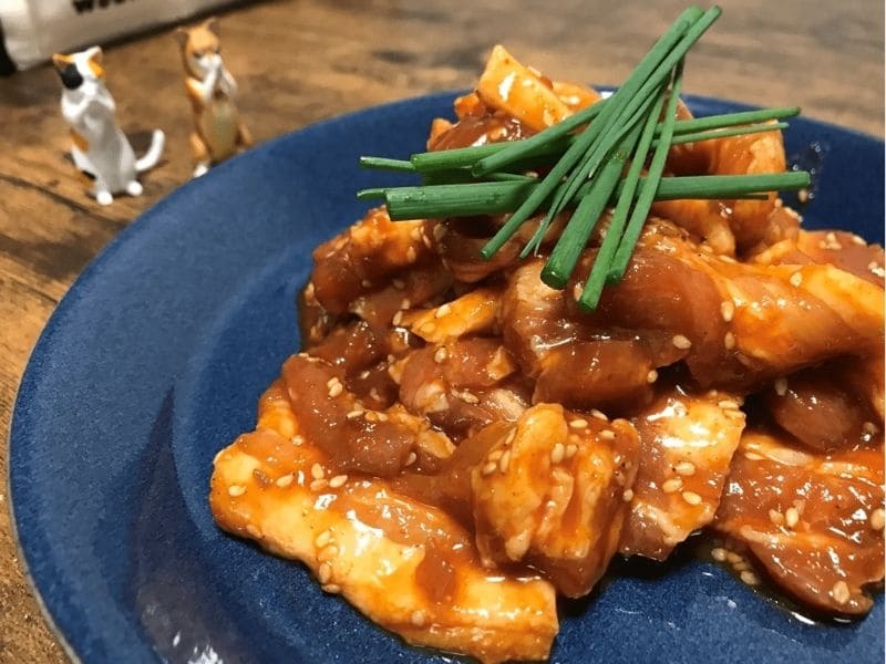 青い皿に盛り付けたコチュジャン風味の味付き豚バラ焼肉