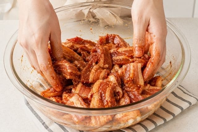 焼肉のタレとコチュジャンを豚バラ肉全体になじませる工程