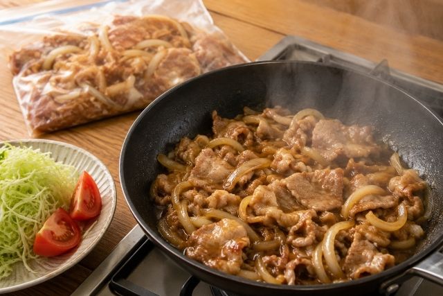 解凍した豚肉と玉ねぎをフライパンで中火で焼く豚生姜焼きの調理工程