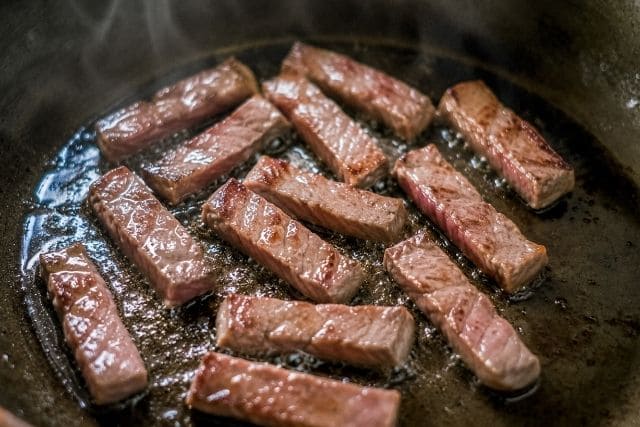 1cm幅の短冊切りにした牛タンを熱したフライパンで香ばしく焼く様子