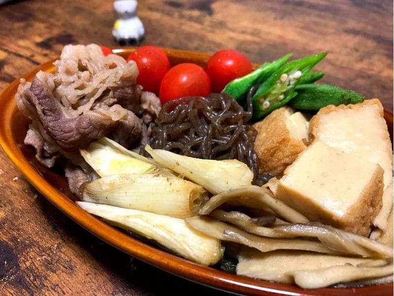 冷やして食べる夏野菜の牛すき焼き。牛肉、厚揚げ、長ネギ、オクラ、ミニトマトを盛り付けた一皿