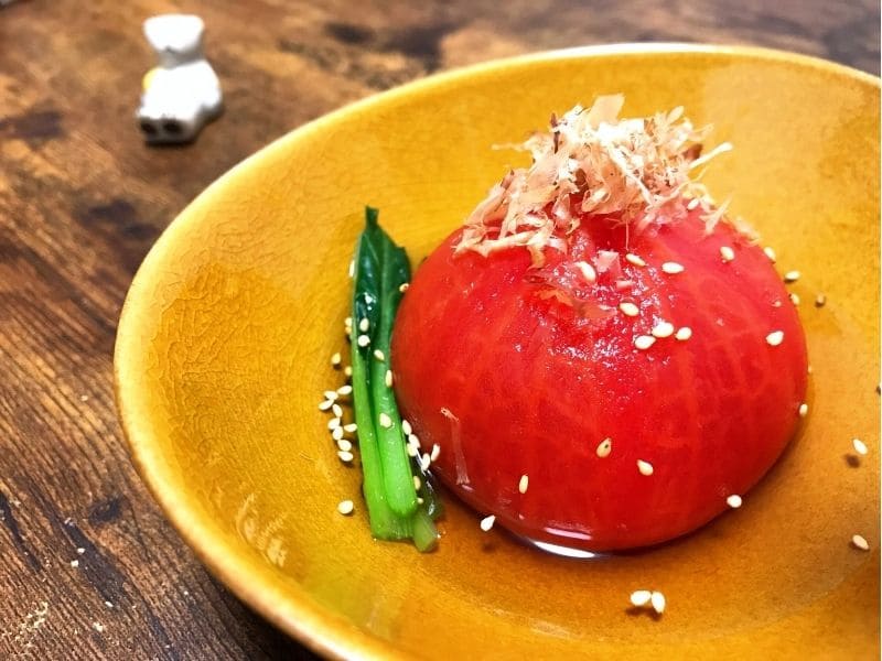 白だしに漬けた冷やしトマトおでんにカツオ節と白ごまをのせた夏の副菜