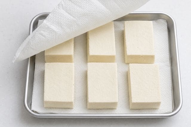 切った木綿豆腐をキッチンペーパーに並べて水切りしている様子
