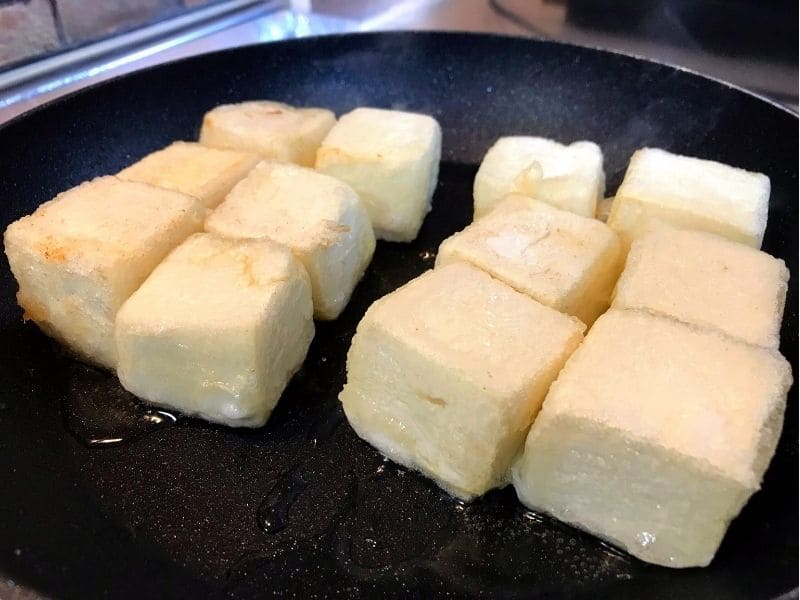 片栗粉をまぶした木綿豆腐をフライパンで香ばしく焼いている様子