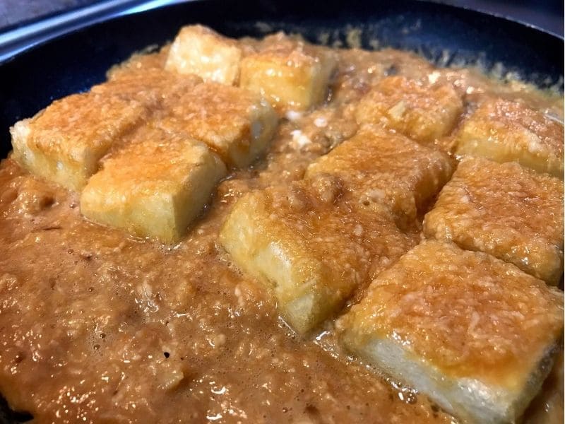 焼いた木綿豆腐に長芋と卵のとろろタネを流し入れて加熱している様子