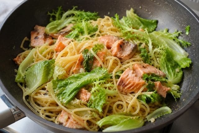 フライパンでサーモンとレタスを軽く炒める柚子胡椒パスタの調理途中