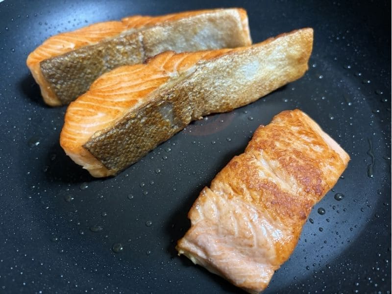 サーモンとレタスの柚子胡椒パスタ用にサーモン切り身をフライパンで焼く様子