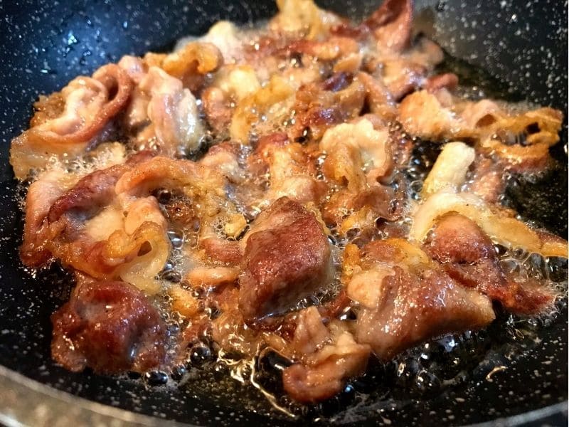 フライパンで豚こま切れ肉を自身の脂を使ってカリカリに揚げ焼きしている様子