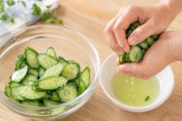 せせりときゅうりのキムチ和え用に、薄切りきゅうりを塩もみして水気を切る工程