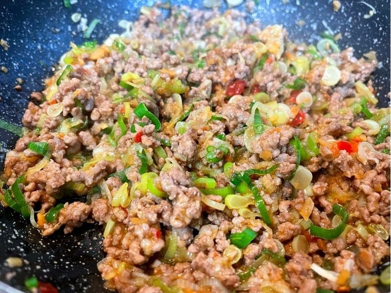 フライパンで豚ひき肉と長ネギを豆板醤と焼肉のタレで炒めている様子