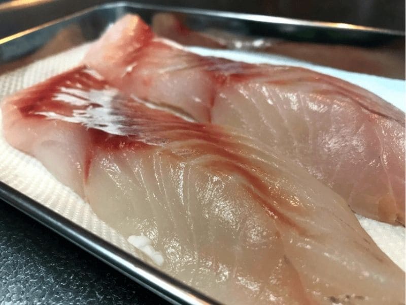 砂糖を水で洗い流し、キッチンペーパーで水分を拭き取ったタラの切り身