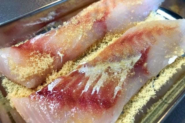 鱈の切り身に砂糖をまぶして臭み取りをしている様子