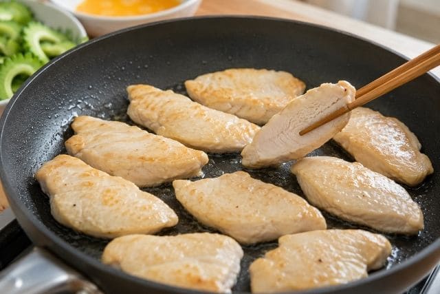 片栗粉で下ごしらえした鶏むね肉を重ならないように焼く調理工程