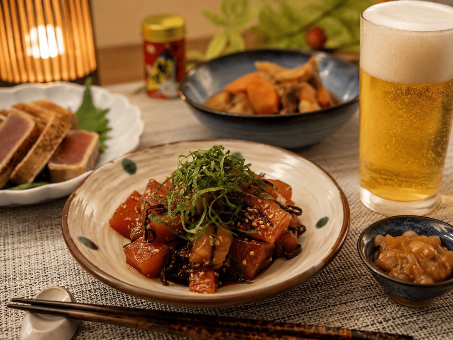 マグロの塩昆布和えと冷たいビールを並べた晩酌の食卓